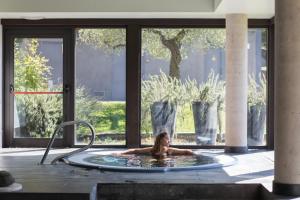 a woman is in a hot tub in a building at Hotel Rural-Spa Resguard Dels Vents in Ribes de Freser