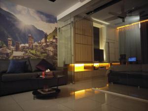 salon z kanapą i obrazem na ścianie w obiekcie 夏天文艺时尚民宿 沙登区 w Kuala Lumpur