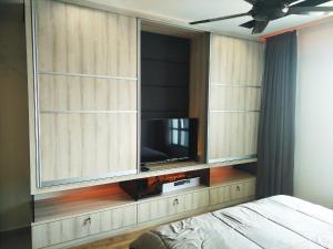 a bedroom with a entertainment center with a flat screen tv at 夏天文艺时尚民宿 沙登区 in Kuala Lumpur