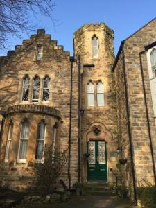 - un vieux bâtiment en pierre avec une porte verte dans l'établissement Farnley Tower Guesthouse, à Durham