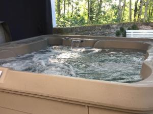 eine Whirlpool-Badewanne mit Wasser in der Unterkunft Unique Holiday Home in Virton with Jacuzzi in Latour