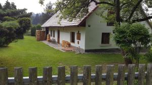 una casa blanca con una valla delante en Chalupa na Šumavě, od soboty do soboty en Nová Ves