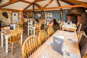 a restaurant with wooden tables and chairs and a fireplace at The Chequers Inn in Rookley