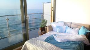sypialnia z łóżkiem i widokiem na ocean w obiekcie Apartament na Klifie 14 w mieście Ustronie Morskie