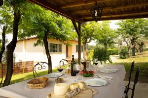 a table with food and wine on a table under a porch at Tenuta Torre Rossa Farm & Apartments in Impruneta