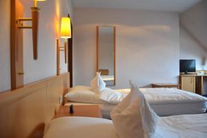 a hotel room with two beds and a mirror at Hotel Restaurant "Zur Post" in Holdorf
