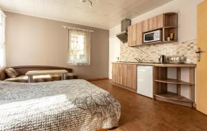 ein Schlafzimmer mit Bett und eine Küche mit Mikrowelle in der Unterkunft Rinvasta in Druskininkai