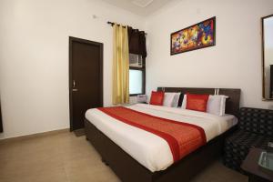 a hotel room with a large bed and a chair at Hotel Sham Villa in Amritsar