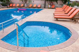 a swimming pool with a bunch of chairs in it at Hotel Central in Sunny Beach