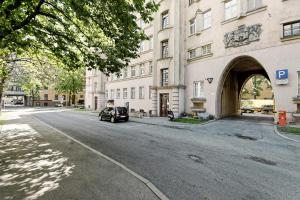 um carro estacionado numa rua em frente a um edifício em Ausekla Deluxe Apartment em Riga