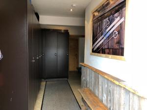 korytarz z czarną szafką i obrazem na ścianie w obiekcie Simal Alm w Saalbach Hinterglemm
