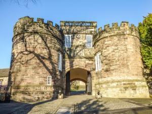einen Eingang zu einer steinernen Burg mit einem Torbogen in der Unterkunft Woodman Cottage in Skipton