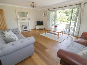 a living room with two couches and a fireplace at Orchard Cottage in Holywell