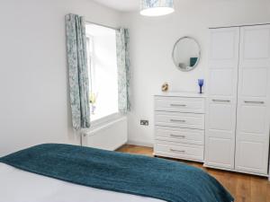 a bedroom with a bed and a dresser and a mirror at 6 Mill Wharf in Berwick-Upon-Tweed