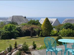 two blue chairs and a table in a yard at Merrydown in Harlech