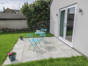 a patio with two chairs and a table in a yard at The Button Box in Huddersfield