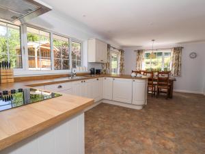 a kitchen with white cabinets and a dining room at Pen Y Maes in Builth Wells