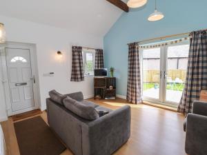 a living room with a couch and a tv at The Button Box in Huddersfield