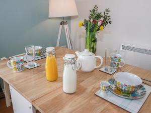 a wooden table with two bottles of orange juice and cups at The Button Box in Huddersfield