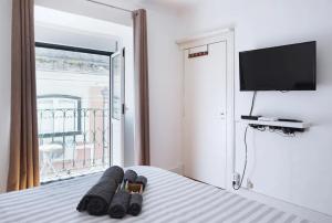 1 dormitorio con 1 cama y TV de pantalla plana en Casa da Alma - Alfama, en Lisboa