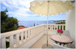 a balcony with a table and an umbrella at Apartments Tomas in Primošten
