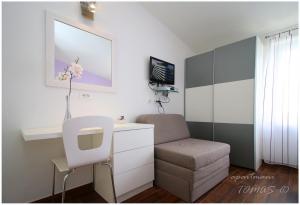 a room with a desk and a chair and a tv at Apartments Tomas in Primošten