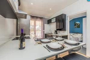 a kitchen with a table with glasses and a bottle of wine at Apartment Brzac in Brzac
