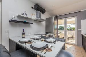 a kitchen with a table with plates and wine glasses at Apartment Brzac in Brzac +19 photos