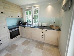 a kitchen with white cabinets and a sink and a window at Terpstich 60A in Morsum