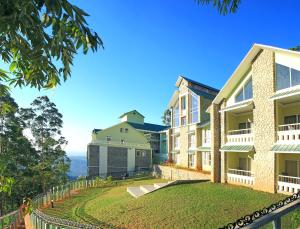 een uitzicht op een gebouw met een tuin bij Devonshire Greens - The Leisure Hotel and Spa in Munnar