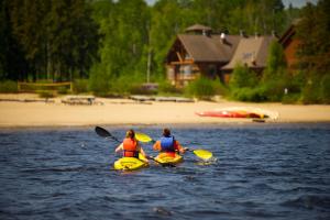 zwei Frauen in Kajaks im Wasser in der Nähe eines Strandes in der Unterkunft Les Condos Du Lac Taureau- Rooms & Condos in Saint-Michel-des-Saints