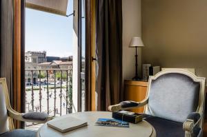 a room with a table and a window with a view at Gran Hotel La Perla in Pamplona