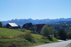 a village on a hill with mountains in the background at Apartamenty i pokoje rodzinne in Czarna Góra