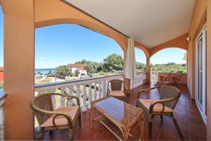 a balcony with chairs and tables and a view of the ocean at Apartment Sapavac in Vir