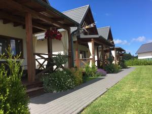 a house with a wooden walkway next to a yard at Zacisze Kopalino in Kopalino