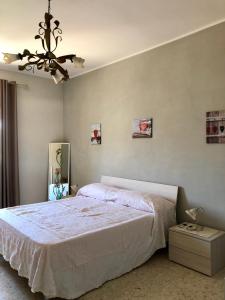 a bedroom with a large bed and a chandelier at Casa vacanze in Terracina