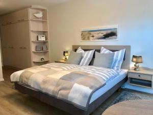 1 dormitorio con 1 cama grande con sábanas azules y blancas en Appartement Auszeit, en Glücksburg
