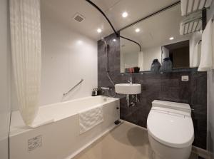 a bathroom with a tub, toilet and sink at Hotel Resol Kyoto Kawaramachi Sanjo in Kyoto