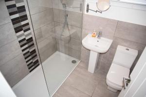 a bathroom with a shower and a toilet and a sink at 8 Glamaig Place in Portree