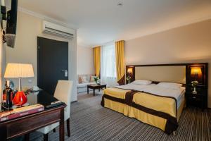 a hotel room with a bed and a desk at Optima Collection Chernihiv in Chernihiv