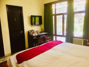 een slaapkamer met een bed, een bureau en een raam bij Homestay Chateau 39 in New Delhi