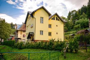 a yellow house with a black roof at Trojanda in Krynica Zdrój