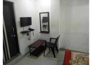 a room with a table and a chair and a mirror at Budget Hotel near Bus Stand in Udaipur