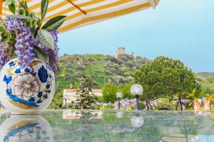 a vase with flowers sitting on a glass table at Villa Maredona in Ascea