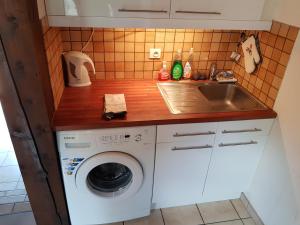 a kitchen with a washing machine and a sink at Résidence Vologne in La Bresse