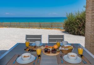 a table with food on it with the beach at Villa Julia in Zakynthos