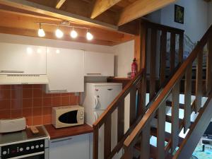a kitchen with white cabinets and a microwave at Résidence Vologne in La Bresse