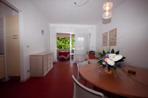 un soggiorno con tavolo in legno e fiori di Residence Diapason a Caorle