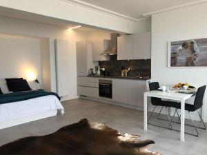 a bedroom with a bed and a table and a kitchen at Seaview Loft in Ostend