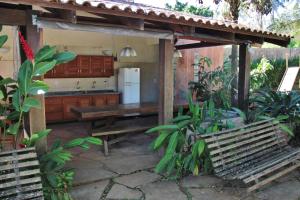 an outdoor kitchen with a bench and a refrigerator at Sossego Homestay in Chapada dos Guimarães